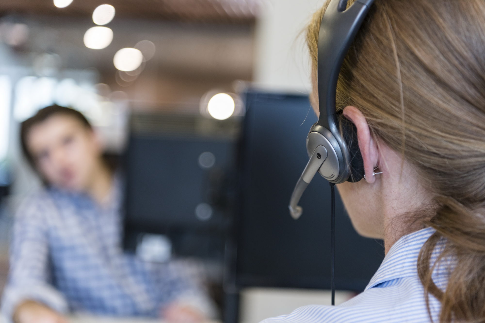 female customer support phone operator with headset at workplace